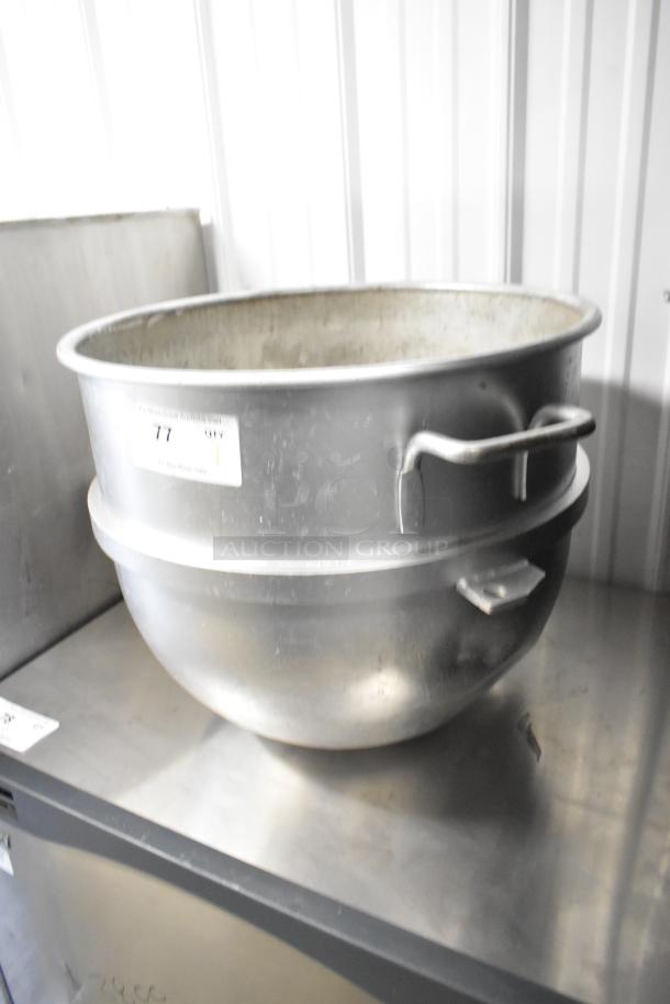 Large metal mixing bowl with handles, visible wear, and auction tag indicating lot number 77.