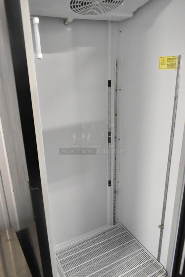 Imbera G319 single door reach-in cooler with poly coated racks, commercial casters. Interior view, label indicates safety instructions.