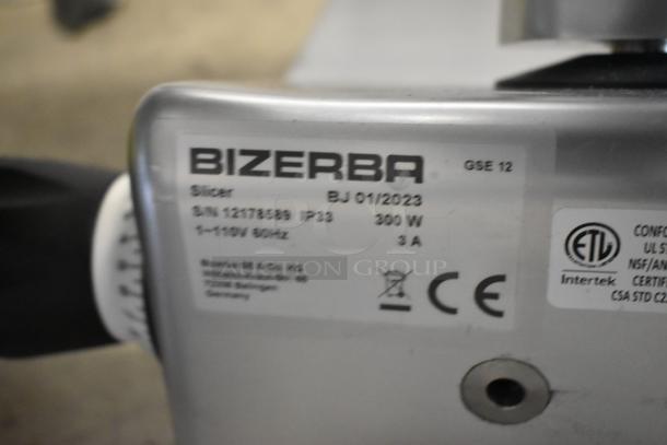 2023 Bizerba GSE 12 commercial meat slicer, label detail shows 110V, 1 Phase, 3A, 300W, with safety and compliance markings.