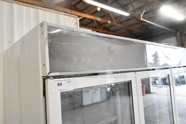 Beverage Air commercial 3-door reach-in cooler with poly-coated racks, metal exterior, visible wear on top, auction tag attached.