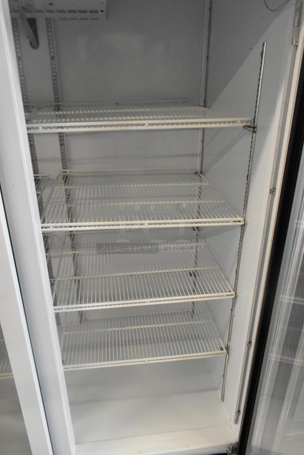 Beverage Air 3-door cooler merchandiser with metal frame and poly-coated racks, in good condition, commercial-grade.