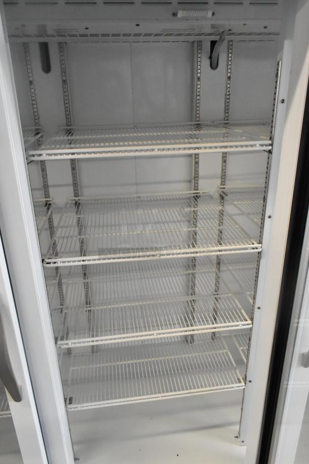 Beverage Air 3-door cooler merchandiser with poly-coated racks, metal construction, and spacious storage in good condition.