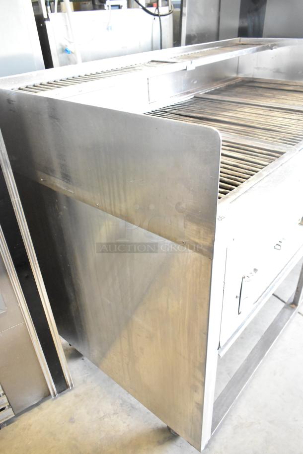 Stainless steel commercial gas grill on casters, used condition, sturdy construction, open grill surface, industrial kitchen use.
