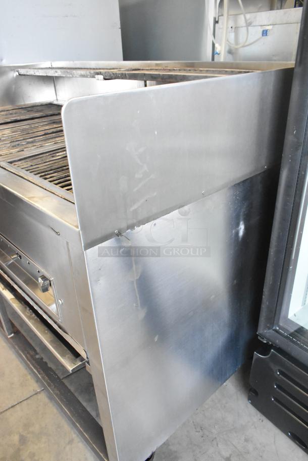 Stainless steel commercial gas grill with casters, used condition, features control knobs and durable design.