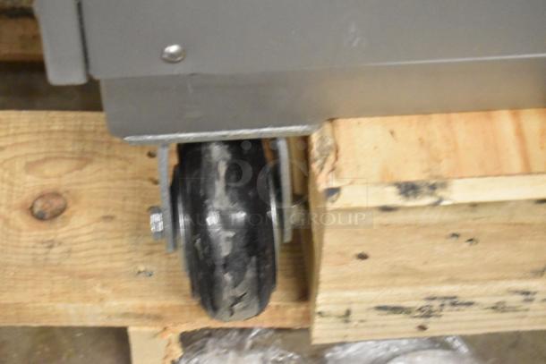 Alt text: Close-up of caster on a Pro-Cut KMG-32 mobile electric meat grinder. Brand new with scratch and dent condition.