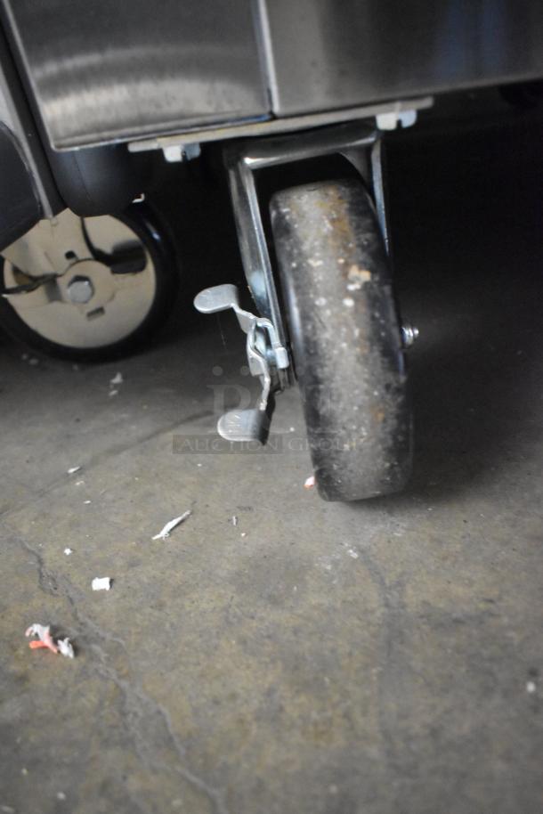 Close-up of caster wheel on a True STR1R-1S-HC stainless steel commercial cooler. Scratch and dent condition.