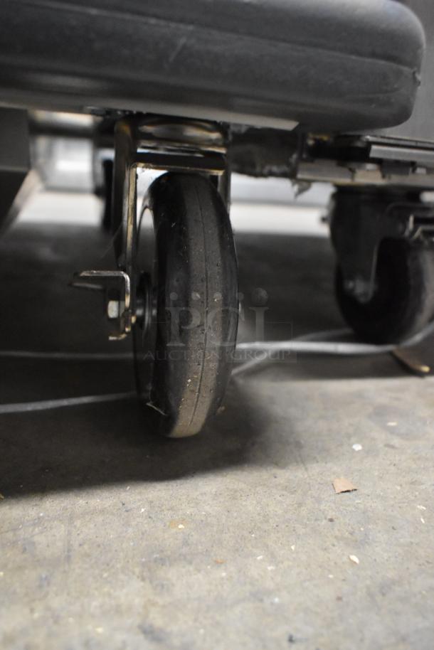 Close-up of a commercial caster on a 2022 Metro C599-SDC-U stainless steel holding/proofing cabinet. Brand new, scratch and dent.