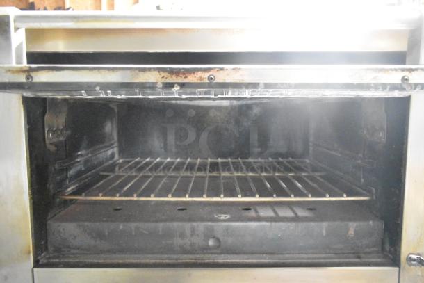 Garland Stainless Steel Commercial Gas Vertical Broiler, well-used, featuring a spacious interior and sturdy wire rack.