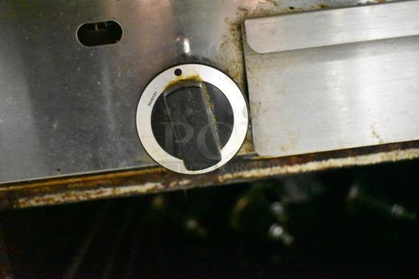Garland stainless steel commercial gas vertical broiler control knob, showing wear and slight discoloration.