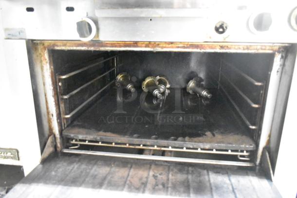 Garland stainless steel commercial gas vertical broiler, lightly worn, interior showing burners and racks, ideal for restaurants.