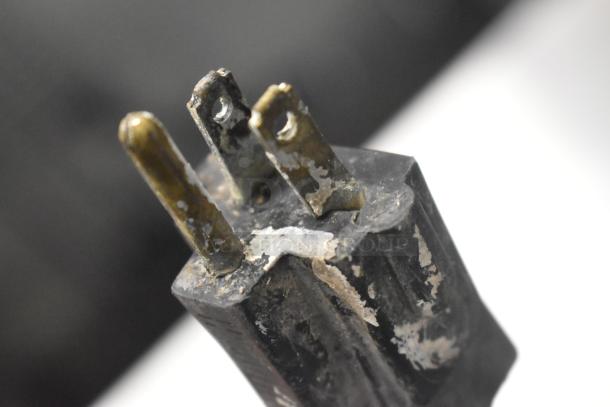 Close-up of a worn electrical plug for a Broaster Warming Display Case, featuring metal prongs with visible corrosion.