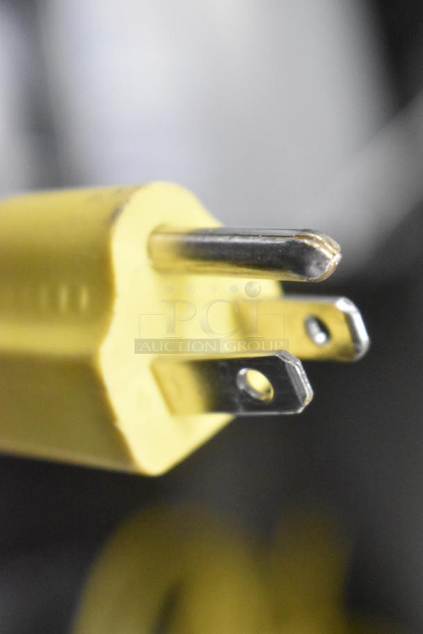 Close-up of a power plug of a Lavex Metal Commercial Floor Burnisher, showcasing prongs for 115 volts, 1 phase.