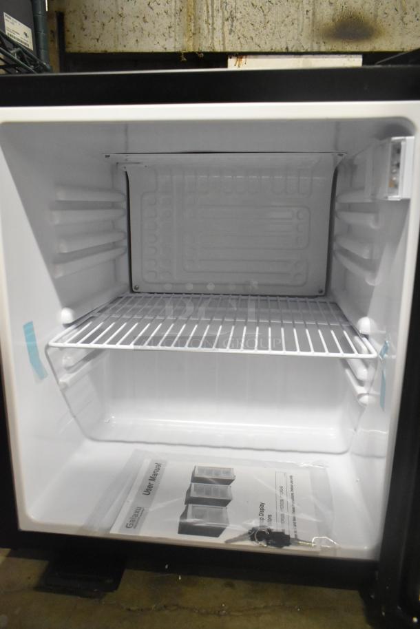 Brand new Galaxy 177CRG2B refrigerated merchandiser, 1.8 cu ft, customizable black countertop design, includes manual and keys.