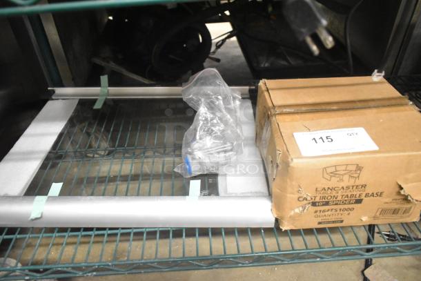 Three brand new scratch and dent items, including a Lancaster Table & Seating 10" Cast Iron Table Base Spider, glass pane, and gas connector. Box labeled with model 164TS1000.