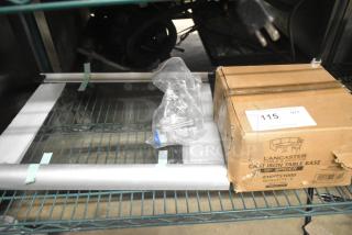 Three brand new scratch and dent items, including a Lancaster Table & Seating 10" Cast Iron Table Base Spider, glass pane, and gas connector. Box labeled with model 164TS1000.