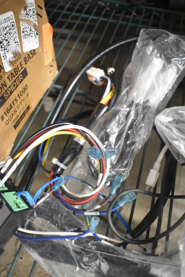 Bundle of six items, including a variety of multicolored wires with connectors, stored on a metal shelf. Box marked with "Combination Table Base Spider" and product code #164T51000 visible. Each wire is in plastic, indicating new or unused condition.