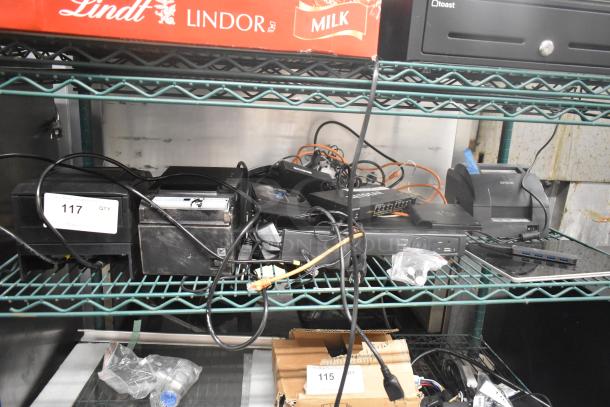 Eight electronic items including SNBC BTP-M300, Epson M267D, Epson M188B receipt printers, Netgear GS308PP switch, visible in a storage setting.