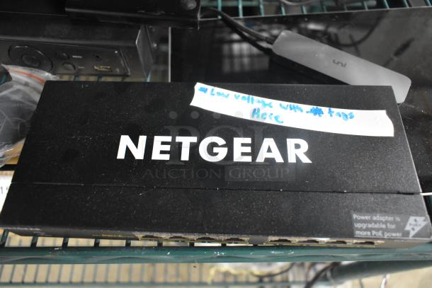 Netgear GS308PP 8 Port Gigabit Ethernet switch on shelf. Features label indicating power adapter upgradable for more PoE power.