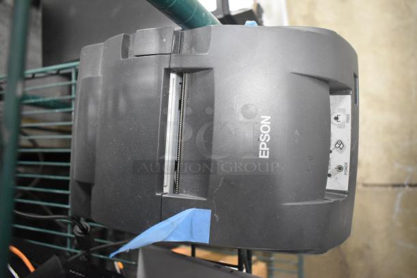 Epson receipt printer, model M267D, in used condition. Features visible logo and labeled buttons.