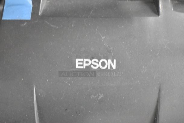 Epson receipt printer with visible logo, part of an auction lot including SNBC BTP-M300, Netgear GS308PP, and open sign.