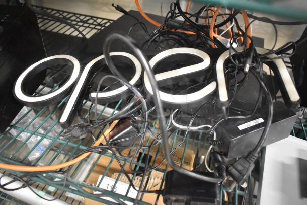Auction lot with tangled cables includes an "Open" sign, indicating multiple items like printers and a Netgear Ethernet switch.