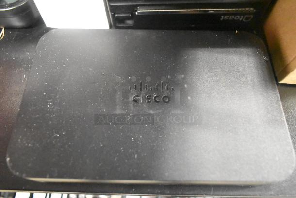 Cisco router with logo, part of an auction set. Slight surface wear visible, indicating use.
