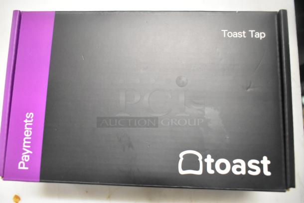 Box displaying Toast Tap branding for payments system; includes monitors, barcode scanner, card reader.