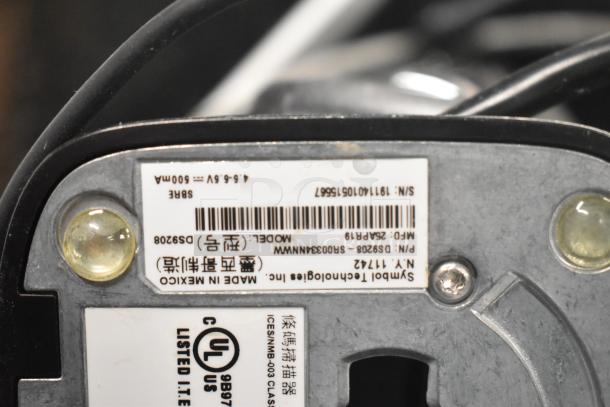 Close-up of a label on a Symbol barcode scanner showing model DS9208, serial number, and UL certification.
