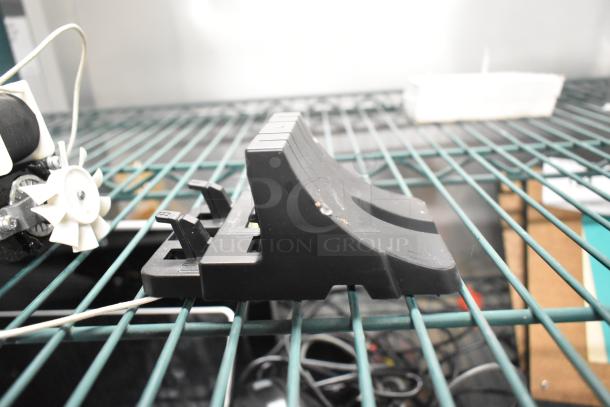 3 various items including a motor on a wire shelf. Black plastic component with levers. Condition appears used.