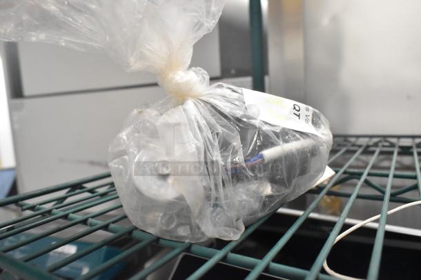 Plastic-wrapped motor placed on a metal shelf with a tag indicating "3 times your bid."