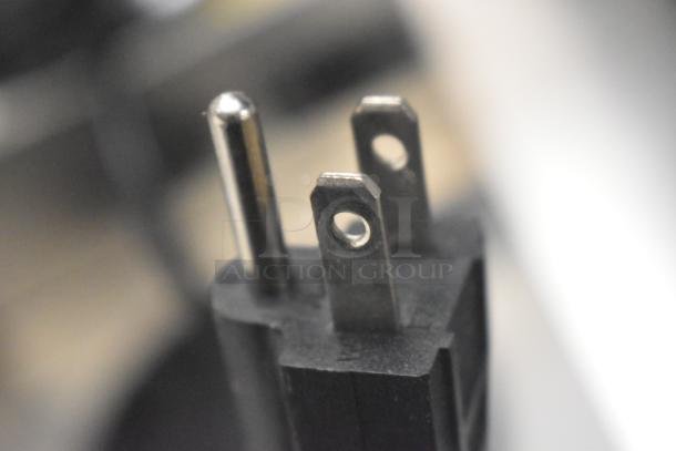 Close-up of a three-prong plug for Avantco 177CMA3L coffee machine, showing clean metal prongs and black plastic casing.