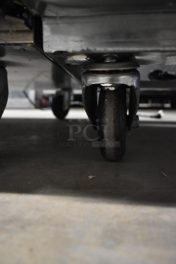 Close-up of the commercial caster on the Atosa MCF8703ES freezer, highlighting mobility. Missing left door, 115V, 1 phase.