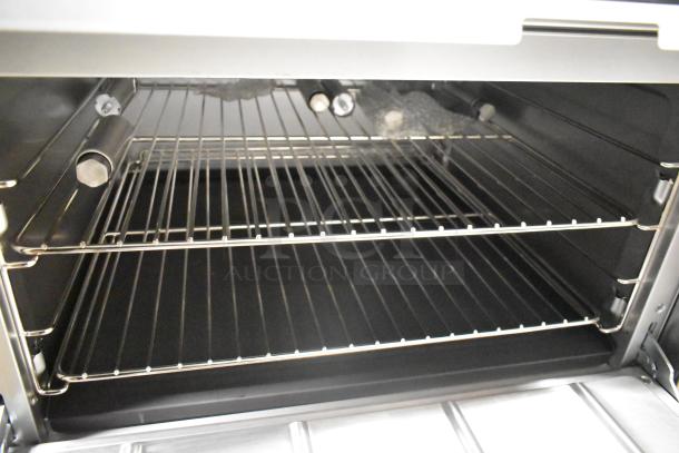 2025 Cooking Performance Group 351S60N stainless steel commercial range interior, showing wire racks. Brand new, scratch and dent condition.