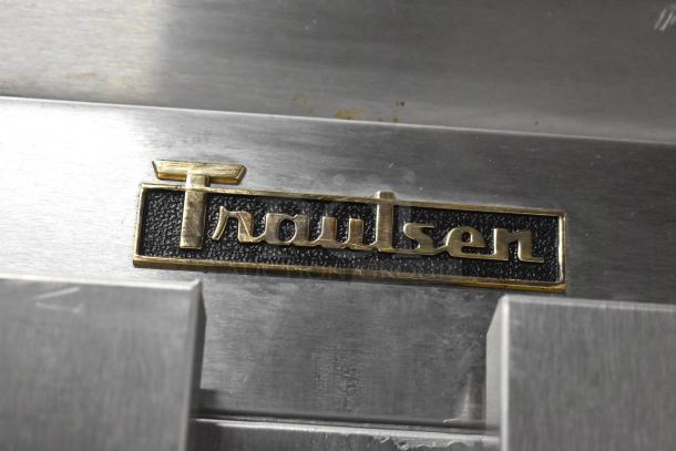 Traulsen G22010 stainless steel logo on commercial 2-door reach-in freezer. Features poly-coated racks and commercial casters.
