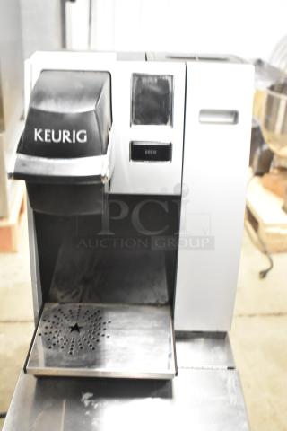 Keurig K150 countertop coffee machine, 120 volts. Features a digital display and drip tray. Some visible wear.
