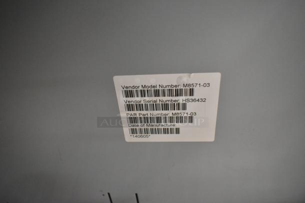 Label showing vendor model number M8571-03 and serial number HS36432 on an auction item including a metal cash drawer.