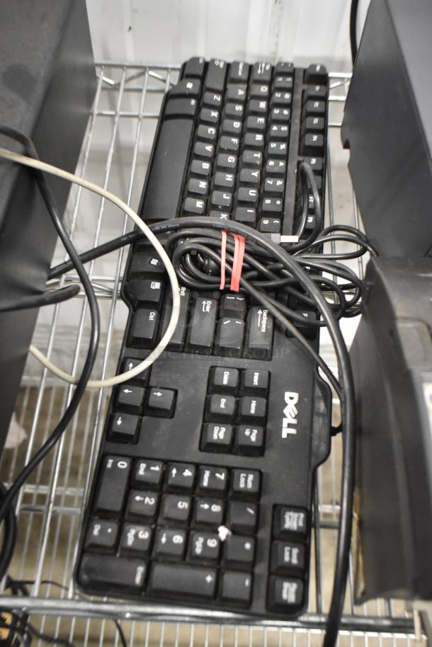 Dell keyboard among electronic equipment, including cables, on a metal shelf. Part of a lot with cash drawer and Epson printers.