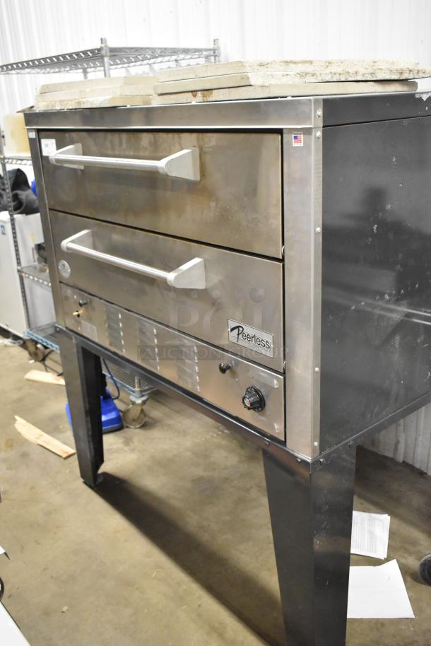 Peerless stainless steel commercial 2-deck pizza oven on metal legs, with sleek design and visible brand label.