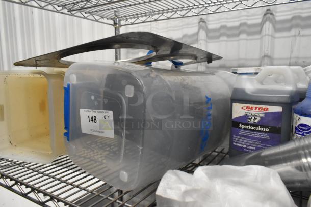 Tiered lot of poly bins with red lids, Betco Spectaculoso Lavender Cleaner, and miscellaneous items on metal shelf.