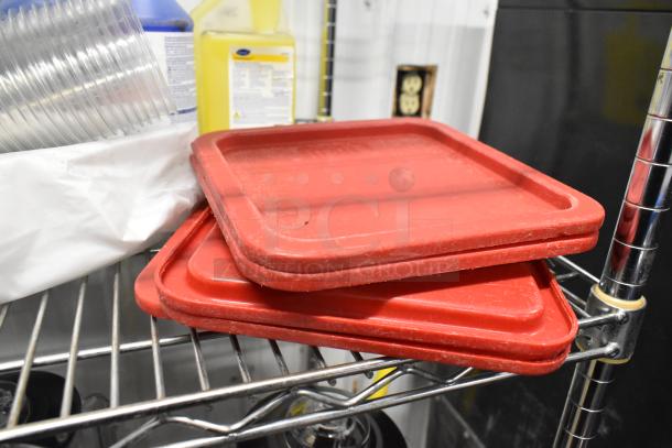 Poly bins with red lids on a metal shelf, beside cleaning supplies including Betco Spectaculoso cleaner.