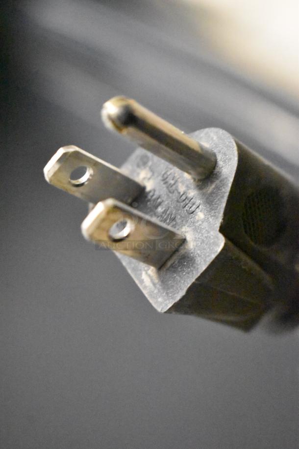 Close-up of a power plug for 115V appliances, compatible with Imbera EVD04 and Galanz GL17BK mini coolers.