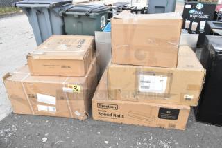 Stack of unopened boxes containing Steelton Speed Rails, Regency brackets, utility cart, and dish table. New condition.