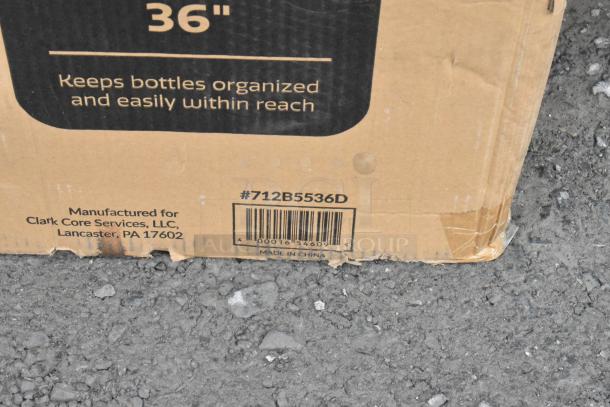 Auction items in packaging with visible label: "Steelton Stainless Steel Double Tier Speed Rail - 36", #712B5536D." Box shows "Manufactured for Clark Core Services, LLC, Lancaster, PA 17602." Item made in China.