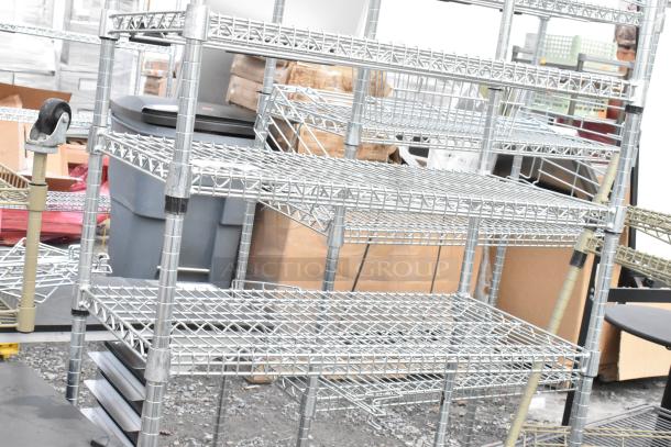 Two metal wire shelving units, industrial style, in used condition. Buyer must dismantle; consider freight costs.