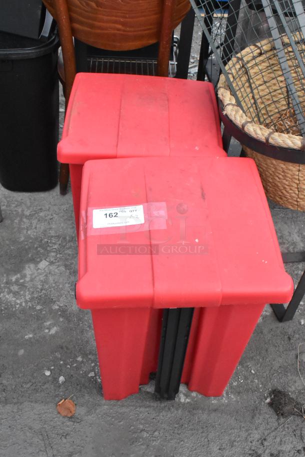 2 red poly foot pedal trash cans with visible lot label. Contents include a fire extinguisher and fan. Pickup required.