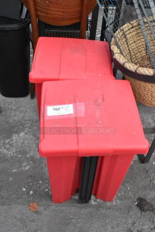 2 red poly foot pedal trash cans with visible lot label. Contents include a fire extinguisher and fan. Pickup required.