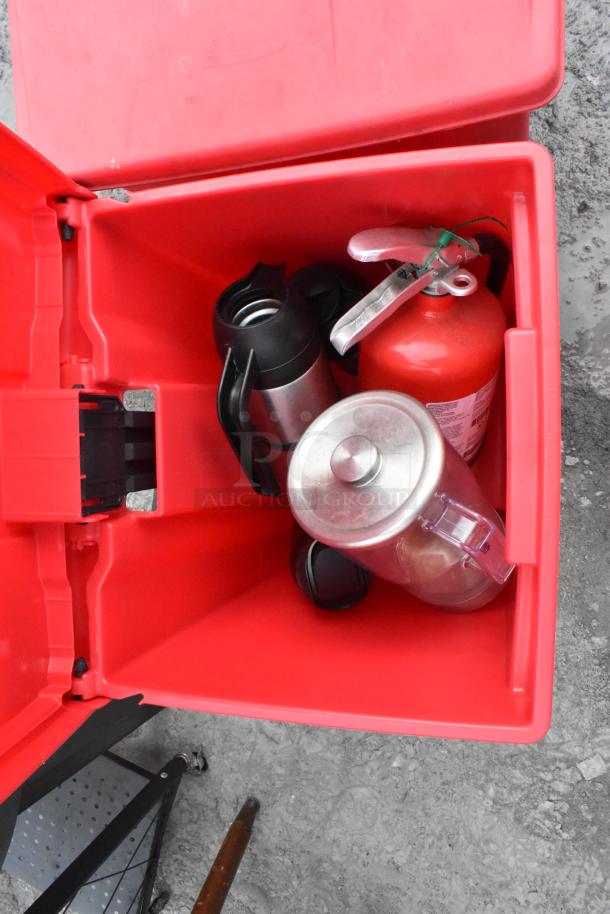 Red poly foot pedal trash can open, containing a fire extinguisher and a fan. Items included with your bid. Buyer pickup required.