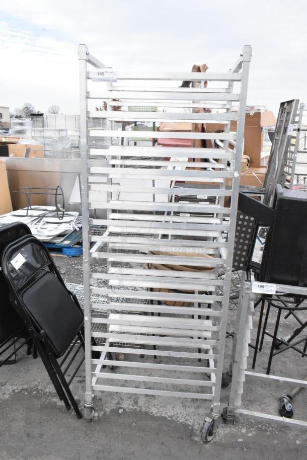 Metal commercial pan transport rack with shelves on commercial casters, in used condition. Tags indicate item number 165.