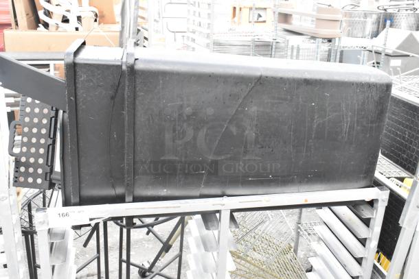 Metal commercial double pan transport rack on casters, includes 2 black trash cans, some wear visible.