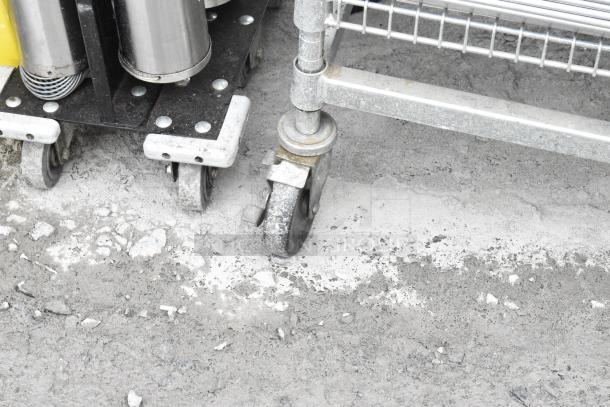 Chrome finish shelving unit with casters shown on concrete, includes metal baking pans and WST969C divider kits. Buyer must dismantle.